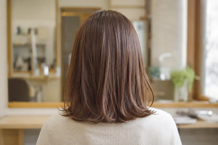 明るい茶に染めた髪の後ろ姿。毛先に自然な立体感が出ている